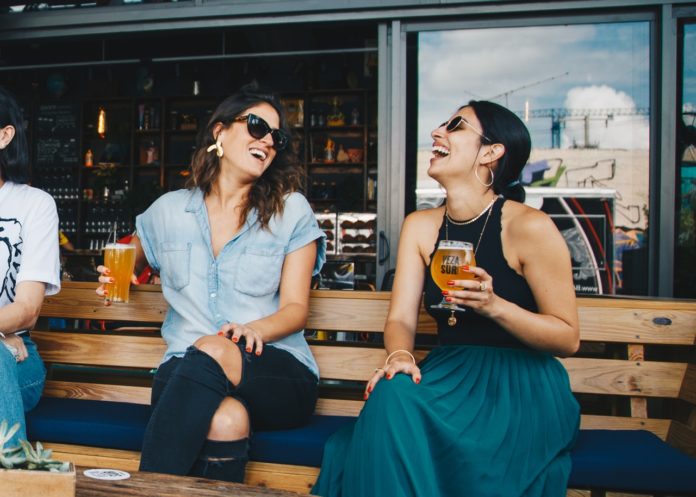 To kvinder griner sammen med øl
