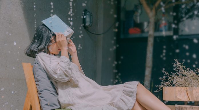 Hold dit flotte tøj tørt Kvinde holder bog over hovedet for at undgå regn