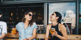 Derfor bør kvinderne også have kondomer på sig To kvinder griner sammen med øl