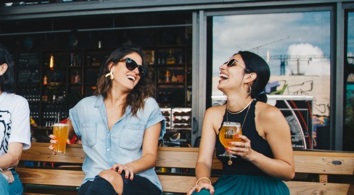 Derfor bør kvinderne også have kondomer på sig To kvinder griner sammen med øl