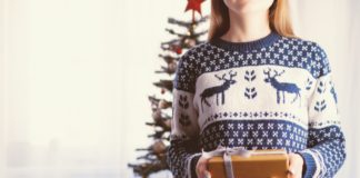 Læs her, hvor let det er at vælge firmajulegaverne selv Pige har julesweater på og giver gave