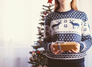 Læs her, hvor let det er at vælge firmajulegaverne selv Pige har julesweater på og giver gave