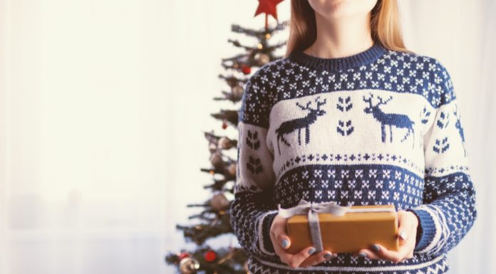 Læs her, hvor let det er at vælge firmajulegaverne selv Pige har julesweater på og giver gave