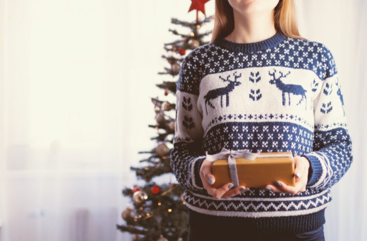 Læs her, hvor let det er at vælge firmajulegaverne selv Pige har julesweater på og giver gave