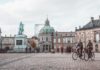 Gør dine københavnerdrømme til virkelighed Person cykler forbi statue inde i københavn