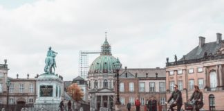 Gør dine københavnerdrømme til virkelighed Person cykler forbi statue inde i københavn