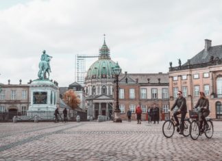 Gør dine københavnerdrømme til virkelighed Person cykler forbi statue inde i københavn