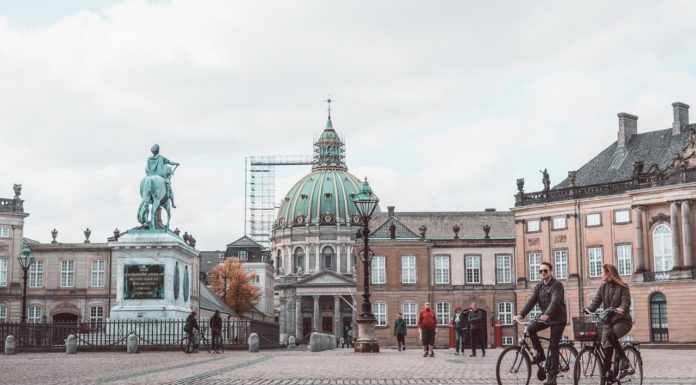 Gør dine københavnerdrømme til virkelighed Person cykler forbi statue inde i københavn