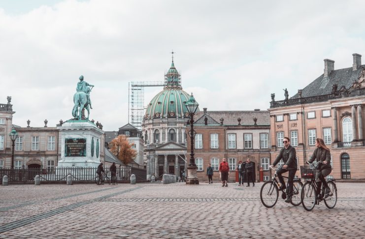 Gør dine københavnerdrømme til virkelighed Person cykler forbi statue inde i københavn