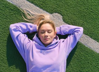 Find en sweatshirt der passer godt til dig Dame ligger på græsplæne