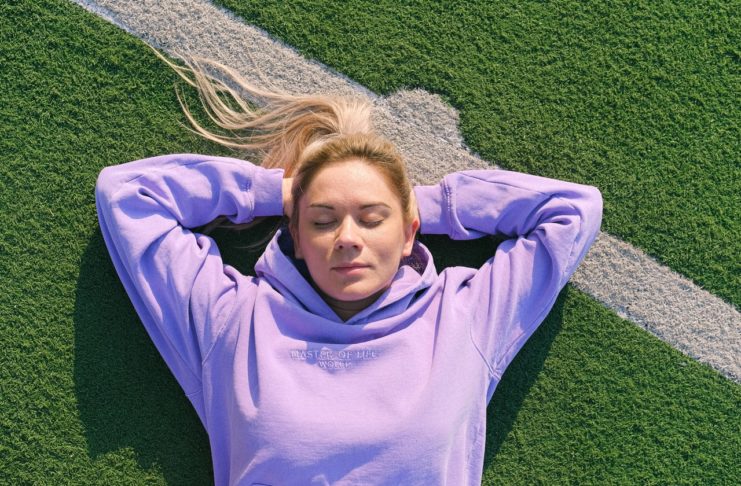 Find en sweatshirt der passer godt til dig Dame ligger på græsplæne